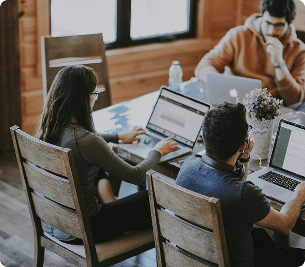 Team of professionals collaborating on laptops in a modern office environment, showcasing teamwork and technology integration